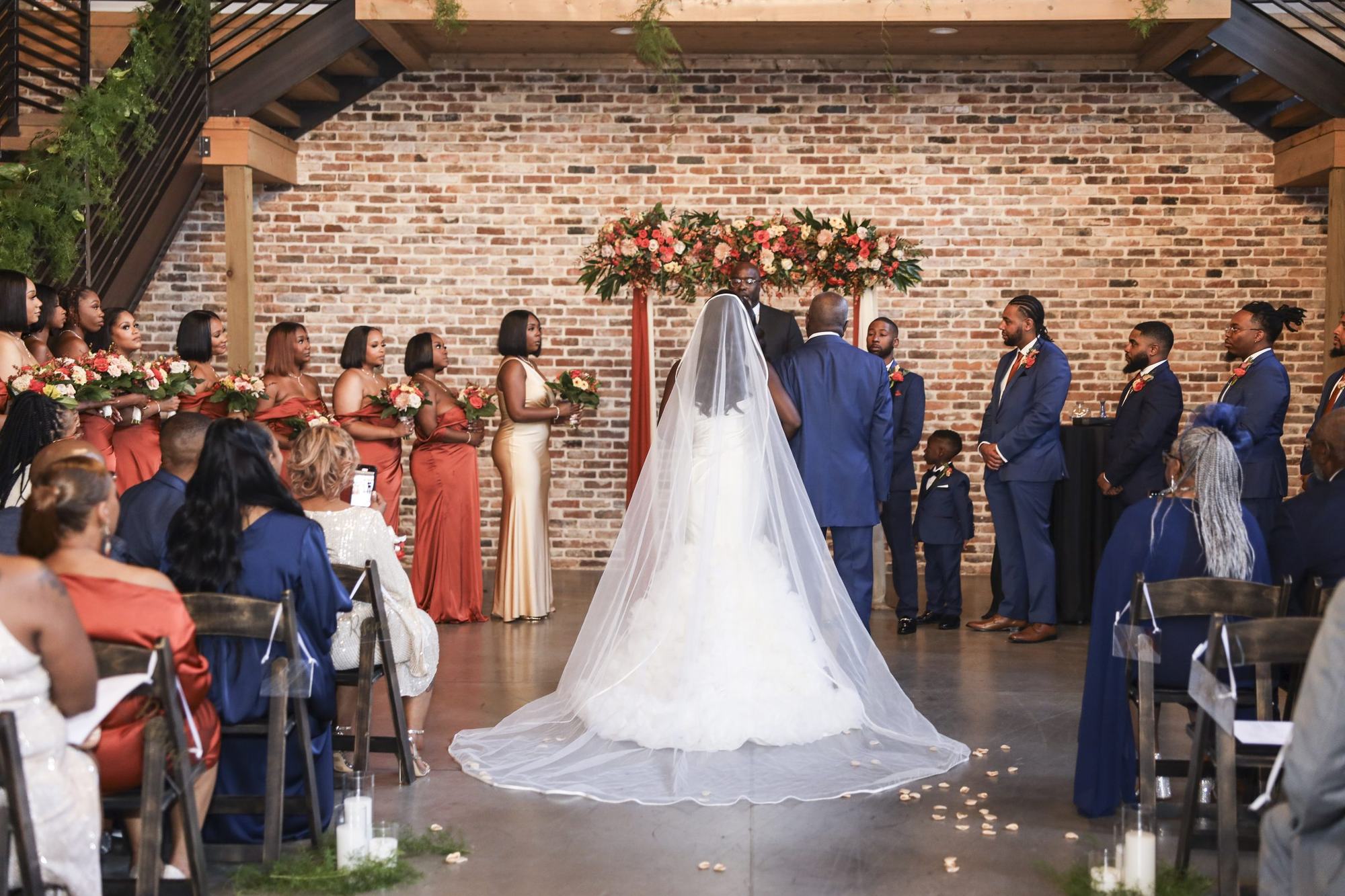 Bride with a cathedral veil walking toward the altar at an Atlanta wedding ceremony